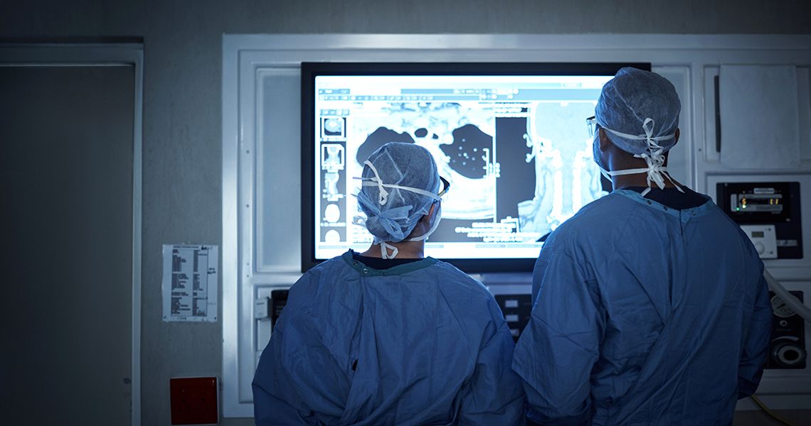 two doctors looking at a monitor in an operating room